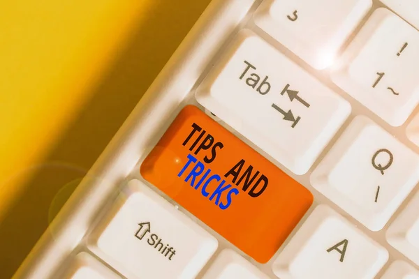 Conceptual hand writing showing Tips And Tricks. Business photo text means piece advice maybe suggestion how improve White pc keyboard with note paper above the white background.