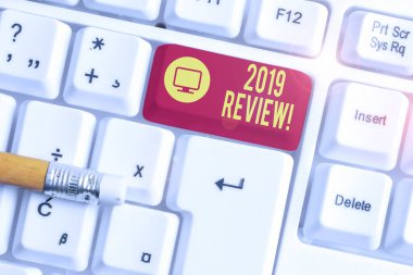Kavramsal el yazısı 2019 İnceleme gösteren. Geçen yıl ki olayları hatırlayan iş fotoğrafı metni ana eylemleri veya iyi beyaz arka plan üzerinde not kağıdı ile Beyaz pc klavye gösterir.