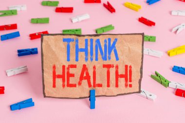 Handwriting text writing Think Health. Concept meaning state of complete physical mental and social well being Colored clothespin papers empty reminder pink floor background office pin.