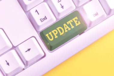 Güncellemeyi gösteren not yazılıyor. İş fotoğrafı gösterimi, yazılım programları gibi daha modern ya da güncel bir şey oluşturur. Beyaz arkaplan üzerinde nota kağıdı olan beyaz pc klavye.
