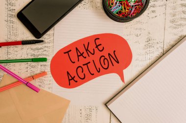 Kelime yazma metni Harekete Geç. İş konsepti, belirli bir sonuç elde etmek için Smartphone kalem, zarf klipleri, konuşma balonu not defteri ahşap..