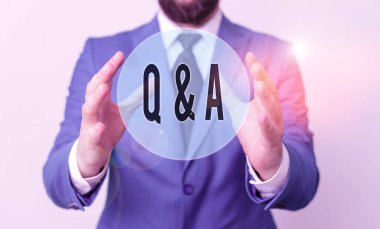 Q ve A Question 'ı yazan el yazısı. Anlamı, gösterinin sorular sorduğu, diğerinin ise masanın önündeki adama cevap verdiği kavram. Cep telefonu ve notlar masanın üzerinde..