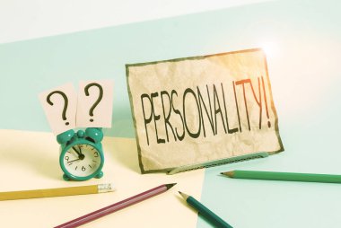 Kişiliği gösteren bir not yazıyorum. İş fotoğrafı kombinasyon özellikleri bireysel karakterler oluşturur Mini boyutta alarm saati Pastel arkaplan üzerinde durgun.