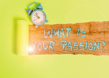 Tutkunuz Sorusu 'nu yazan el yazısı metni. Kavram, güçlü ve zar zor kontrol edilebilen duygularını sormaktır. Alarm saati ve karton yırtılması, klasik bir masanın arkasına yerleştirilmiş.