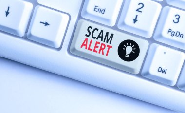 Kelime yazma metin Scam Alert. Beyaz arka plan tuşu kopyalama alanı üzerinde boş not kağıdı ile bir pazarlık Beyaz pc klavye umudu iddia istenmeyen e-posta için İş kavramı.