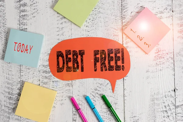 Text sign showing Debt Free. Conceptual photo does not owning any money to any individual or companies Ballpoints pens blank colored speech bubble sticky notes wooden background.