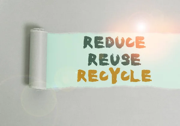 Texte manuscrit Réduire la réutilisation Recycler. Concept signifiant comportement écologiquement responsable du consommateur Carton qui est déchiré au milieu placé au-dessus d'une toile de fond de table simple . — Photo