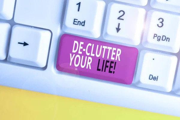 Text sign showing De Clutter Your Life. Conceptual photo remove unnecessary items from untidy or overcrowded places White pc keyboard with empty note paper above white background key copy space. — Stock Photo, Image