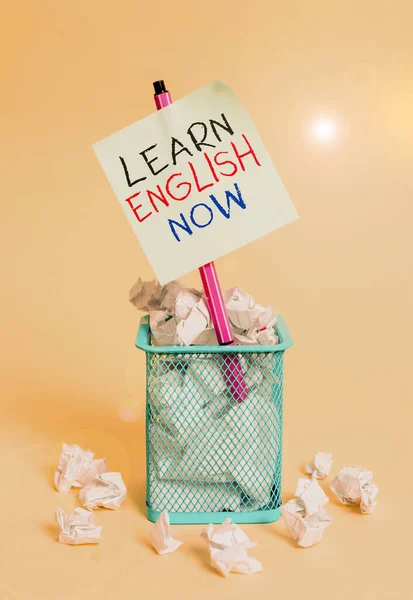 Пишучи нотатки, показуючи "Навчайся англійської мови тепер". Бізнес-фотографія, що показує нагромадження знань і навичок англійської мови, зім'яв папір і стаціонарний з папером, поміщеним у сміттєзвалище.. — стокове фото