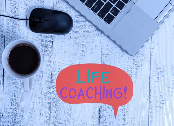 Handschrift tekst Life Coaching. Concept betekent demonstreren gebruikt om te helpen tonen bereiken van hun doelen in carrière Open metalen laptop spraak bel muis koffiekopje vintage houten tafel. — Stockfoto