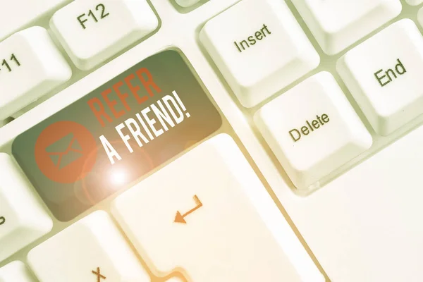 Tulisan tangan konseptual menunjukkan Refer A Friend. Foto bisnis mengarahkan seseorang ke orang lain atau mengirimkan sesuatu seperti hadiah Pc keyboard putih dengan catatan kertas di atas latar belakang putih . — Stok Foto