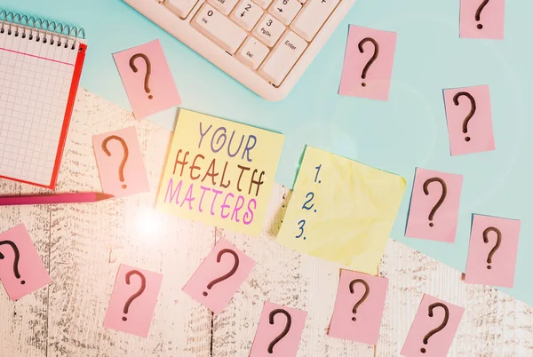 Textschild, das Ihre Gesundheit anzeigt. Gute Gesundheit ist unter anderem das Wichtigste: Schreibwerkzeuge, Computer und Mathe-Buch auf dem Holztisch. — Stockfoto