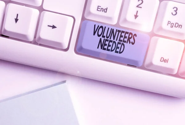 Writing note showing Volunteers Needed. Business photo showcasing need work or help for organization without being paid White pc keyboard with note paper above the white background.