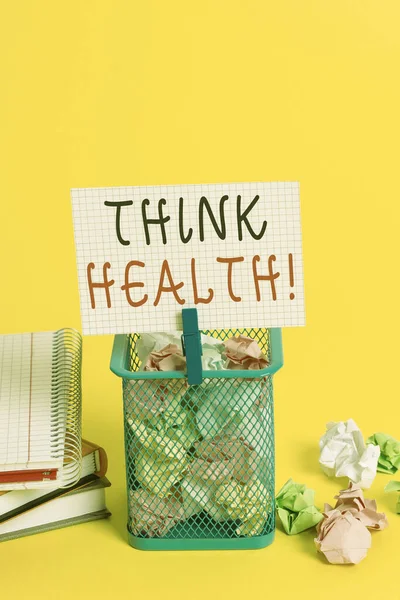 Conceptual hand writing showing Think Health. Business photo text state of complete physical mental and social well being Trash bin crumpled paper clothespin office supplies yellow.