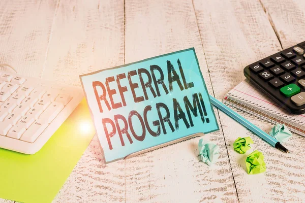 Text sign showing Referral Program. Conceptual photo internal recruitment method employed by organizations Notepaper stand on buffer wire in between computer keyboard and math sheets.