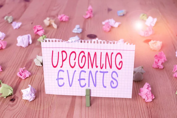 Text sign showing Upcoming Events. Conceptual photo the approaching planned public or social occasions Colored crumpled papers empty reminder wooden floor background clothespin.