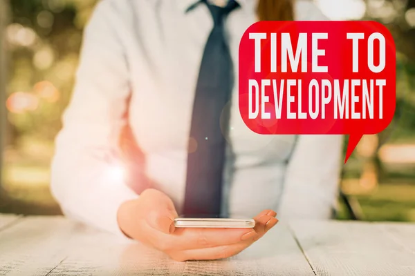 A fejlődési időt bemutató feljegyzés. Üzleti fotó, amely azt az időtartamot mutatja be, amely alatt a vállalat nő vagy fejlődik Női üzletember ül asztalnál és tartja a mobiltelefont. — Stock Fotó