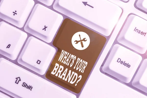 Handgeschreven tekst wat is uw merk vraag. Concept betekenis vragen over product logo doet of wat u communiceert wit PC-toetsenbord met lege Opmerking papier boven witte achtergrond sleutel kopiëren ruimte. — Stockfoto