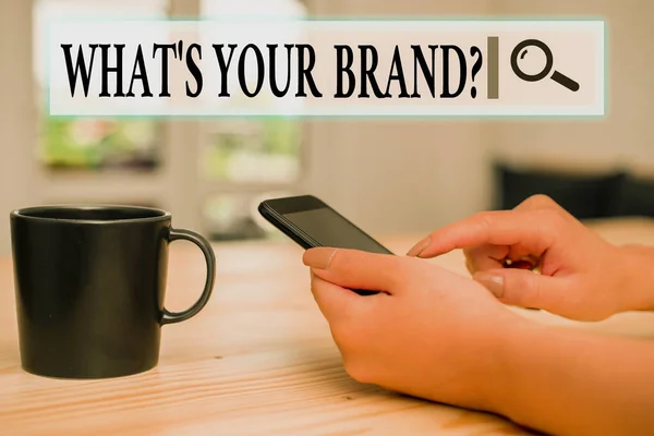 Writing note showing What S Your Brand Question. Business photo showcasing asking about product logo does or what you communicate woman using smartphone and technological devices inside the home.