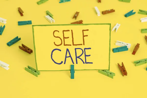 Написание текста Self Care. Business concept for the practice of taking action to improve one 's is own health Colored clothespin papers empty reminder yellow floor background office . — стоковое фото