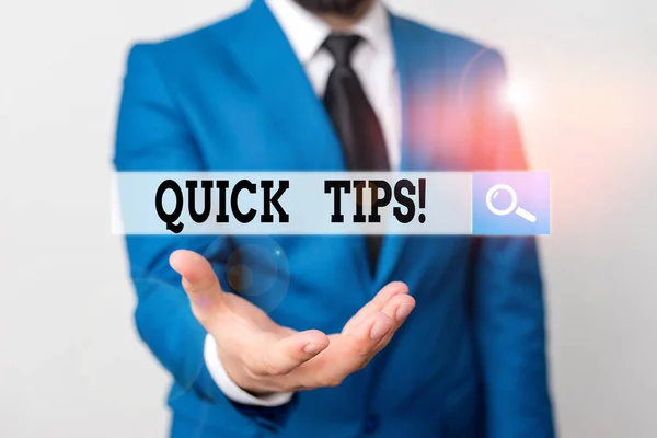 Nota de escrita mostrando Quick Tips. Foto de negócios mostrando pequeno, mas particularmente útil pedaço de conselho prático Homem na frente da mesa. Telemóvel e notas na mesa . — Fotografia de Stock