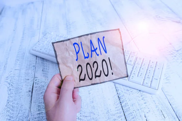Scrivere a mano concettuale che mostra Piano 2020. Business foto testo proposta dettagliata facendo raggiungere qualcosa il prossimo anno Uomo in possesso colorato promemoria quadrato pavimento in legno di carta . — Foto Stock