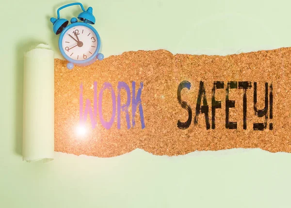 Texto para escrita de palavras Work Safety. Conceito de negócio para políticas e procedimentos em vigor para garantir a saúde dos funcionários Relógio despertador e papelão rasgado colocados acima de um pano de fundo de mesa clássico de madeira . — Fotografia de Stock