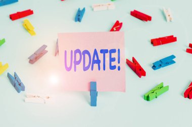 Text sign showing Update. Conceptual photo make something more modern or up to date like software programs Colored clothespin papers empty reminder blue floor background office pin.