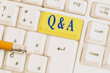 Soru sorulur ve beyaz arka plan üzerinde not kağıdı ile Beyaz pc klavye yanıtlar olarak tanımlanan Q Ve A. İş fotoğraf vitrin gösteren not yazma.