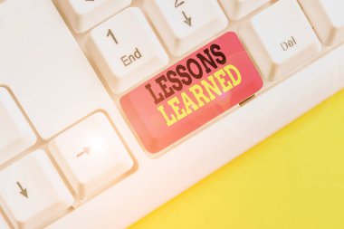 Öğrenilen Dersleri gösteren kavramsal el yazısı. Aktif beyaz arka plan üzerinde not kağıdı ile Beyaz pc klavye saolmalıdır damıtılmış proje damıtMa deneyimleri vitrine.