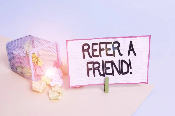Conceptual hand writing showing Refer A Friend. Business photo text direct someone to another or send him something like gift Trash bin crumpled paper clothespin reminder office supplies.