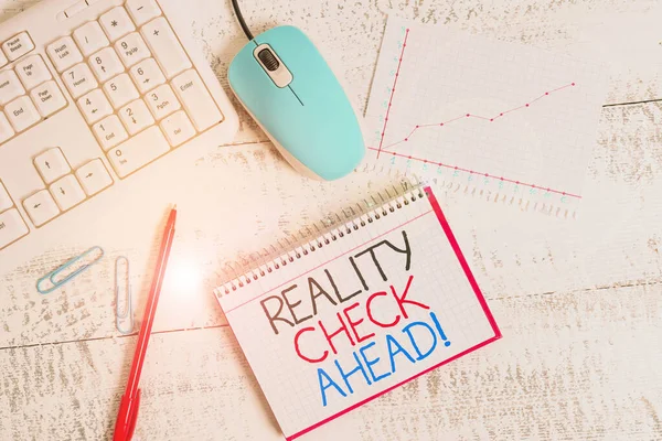 Writing note showing Reality Check Ahead. Business photo showcasing makes them recognize truth about situations or difficulties Wood desk office appliance computer equipaments charts paper slot.