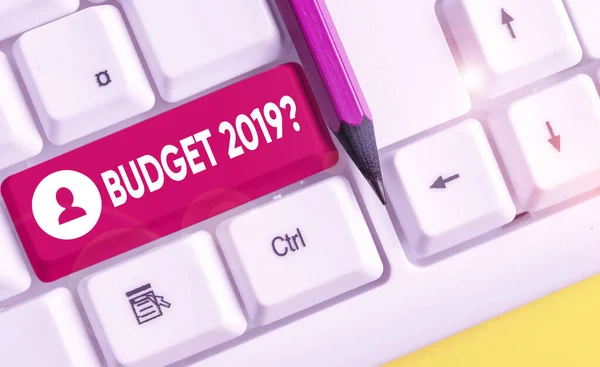 単語の書き込みテキスト予算2019質問。来年の収入と支出の見積もりのためのビジネスコンセプト 白い背景キーのコピースペースの上に空のノート紙を持つ白いPCキーボード. — ストック写真