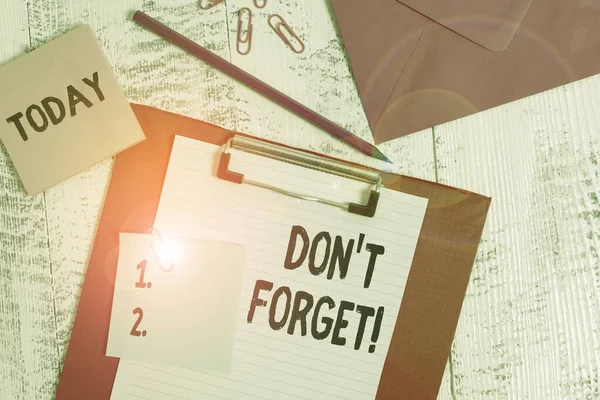 Κείμενο γραφής λέξεων Don T Forget. Επιχειρηματική έννοια για να χρησιμοποιηθεί για να υπενθυμίσει κάποιος για σημαντικό γεγονός ή λεπτομέρεια Πρόχειρο χαρτί φύλλο μολύβι σημείωμα φάκελο κλιπ σημειωματάριο ξύλινο φόντο. — Φωτογραφία Αρχείου