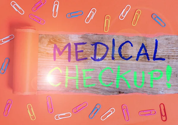 Text sign showing Medical Checkup. Conceptual photo thorough physical examination includes variety of tests Paper clip and torn cardboard placed above a wooden classic table backdrop.