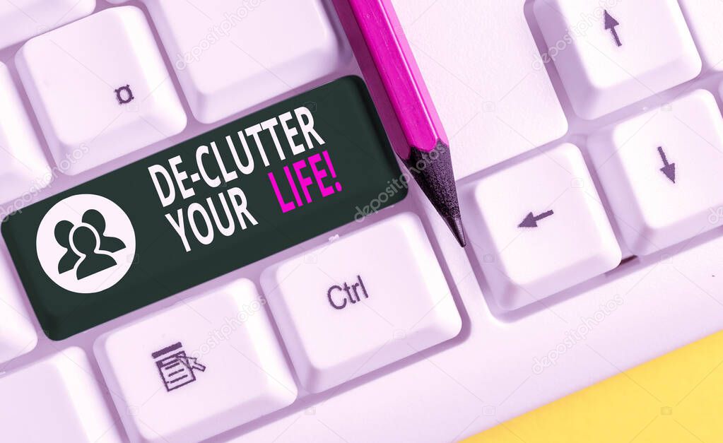 Conceptual hand writing showing De Clutter Your Life. Business photo text remove unnecessary items from untidy or overcrowded places White pc keyboard with note paper above the white background.