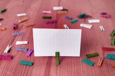 Dikdörtgen kare şekilli mandallı renkli kağıt ya da arka planda kağıt topu. Masanın etrafına renkli buruşuk notlar dağılmış. Ofis Malzemeleri Masada.