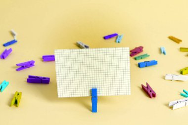 Dikdörtgen kare şekilli mandallı renkli kağıt ya da arka planda kağıt topu. Masanın etrafına renkli buruşuk notlar dağılmış. Ofis Malzemeleri Masada.