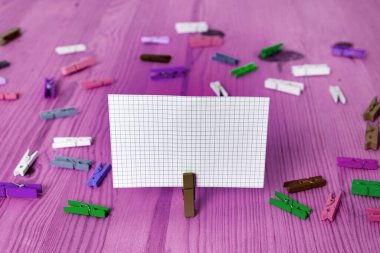 Dikdörtgen kare şekilli mandallı renkli kağıt ya da arka planda kağıt topu. Masanın etrafına renkli buruşuk notlar dağılmış. Ofis Malzemeleri Masada.