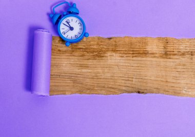 Çalar saati ve çivileri ahşap masanın üzerine yerleştirilmiş rulo şeklinde sökülmüş karton. Ahşap bir zemindeki kalın yırtık kağıt. Flat Lays Fotoğrafçılığı Düzenleme Sanatsal Yolu