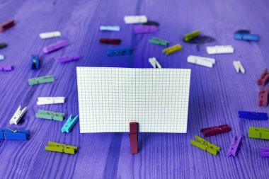 Dikdörtgen kare şekilli mandallı renkli kağıt ya da arka planda kağıt topu. Masanın etrafına renkli buruşuk notlar dağılmış. Ofis Malzemeleri Masada.