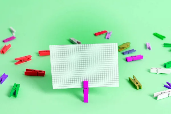 Rechteck Quadrat geformtes farbiges Papier mit Wäscheklammer oder Papierkugel in einem hellen Hintergrund. Bunt zerknitterte Notizen verteilen sich auf dem Tisch. Bürobedarf in einem Schreibtisch. — Stockfoto