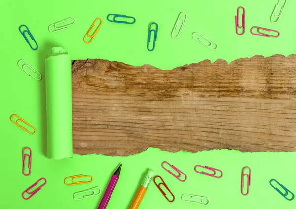 Gewalst gescheurd karton met wekkerklok en pennen geplaatst Ontworpen boven houten tafel. Dikke gescheurd papier op een gestructureerde houten achtergrond. Artistieke manier van het regelen van Flat Lays Fotografie — Stockfoto