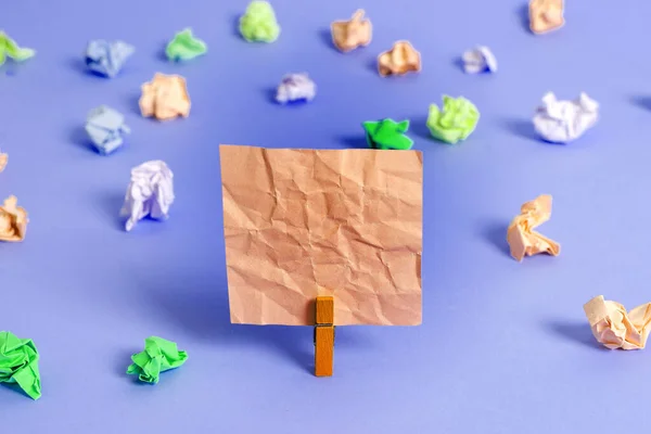 Rechthoekig vierkant gevormd gekleurd papier met wasknijper of papieren bal in een lichte achtergrond. Kleurrijke kreukelige notitie verspreid over de tafel. Kantoorbenodigdheden in een bureau. — Stockfoto