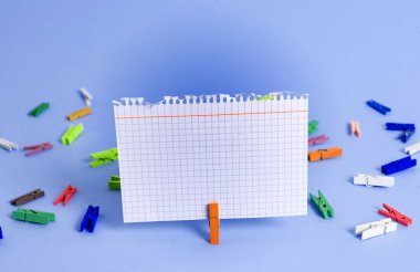 Dikdörtgen kare şekilli mandallı renkli kağıt ya da arka planda kağıt topu. Masanın etrafına renkli buruşuk notlar dağılmış. Ofis Malzemeleri Masada.