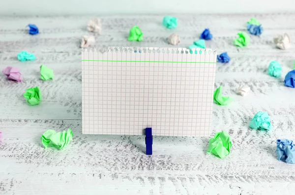 Rechthoekig vierkant gevormd gekleurd papier met wasknijper of papieren bal in een lichte achtergrond. Kleurrijke kreukelige notitie verspreid over de tafel. Kantoorbenodigdheden in een bureau. — Stockfoto