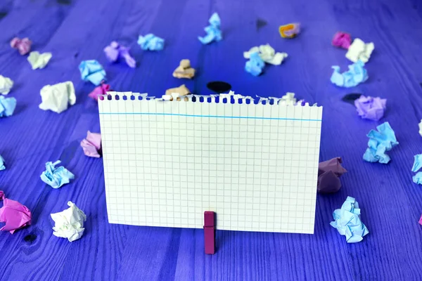 Rechthoekig vierkant gevormd gekleurd papier met wasknijper of papieren bal in een lichte achtergrond. Kleurrijke kreukelige notitie verspreid over de tafel. Kantoorbenodigdheden in een bureau. — Stockfoto