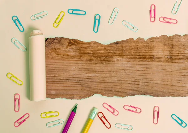 Carton déchiré roulé avec réveil et goupilles placées au-dessus de la table en bois. Papier épais déchiré sur fond de bois texturé. Manière artistique d'organiser la photographie de couches plates — Photo