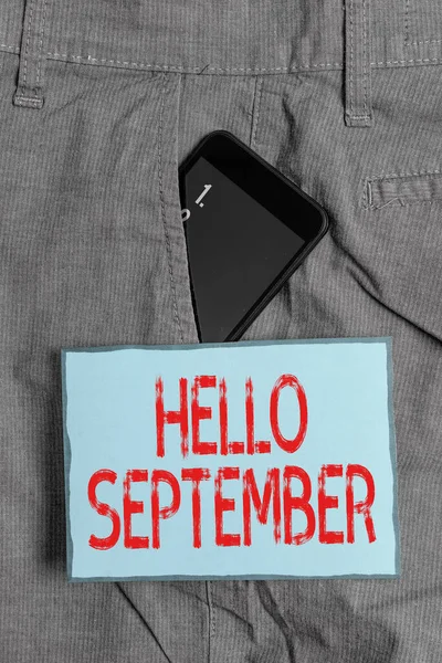 Escribir texto a mano Hola Septiembre. Concepto que significa saludo utilizado en conmemorar el noveno mes del año dispositivo Smartphone dentro de pantalones de trabajo formales bolsillo delantero cerca de papel de nota . —  Fotos de Stock