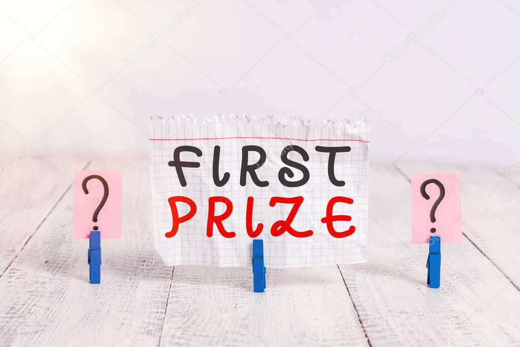 Conceptual hand writing showing First Prize. Business photo showcasing most coveted prize that is only offered to the overall winner Crumbling sheet with paper clips placed on the wooden table.